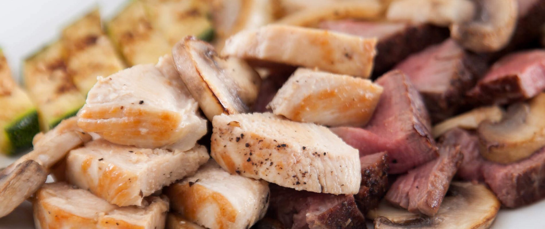 Close up of a pile of cooked chicken, mushroom and steak