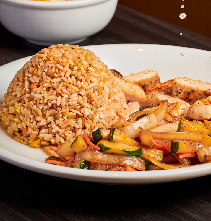 A plate of rice, vegetables and chicken.